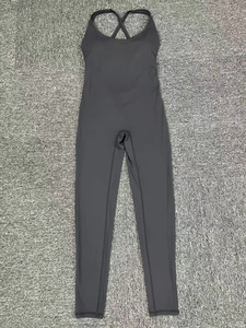 Détails des bretelles croisées et du tissu élastique gris d'une combinaison de yoga
