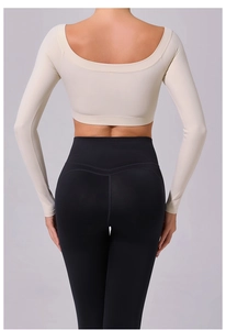 Rear view of cream long sleeve open back yoga top and high waist black leggings set