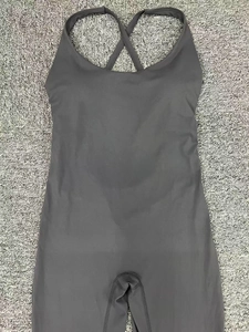 Détail des bretelles croisées et du tissu technique sur le body de yoga gris foncé
