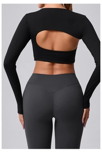 Détail d'un haut de yoga noir dos nu à manches longues et d'un legging de sport gris