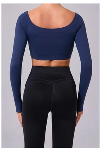 Detail of navy blue open back crop top and black high waisted yoga leggings on a model
