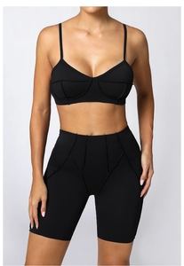 Détail d'un ensemble de yoga noir à coutures contrastées avec short de cycliste taille haute