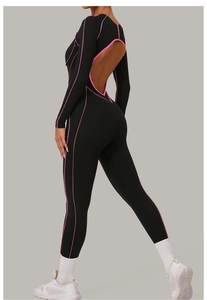 Détail du dos nu et des coutures contrastées roses sur le body de yoga noir