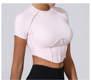 Détail du crop top ajusté rose clair avec coutures contrastées et ourlet incurvé