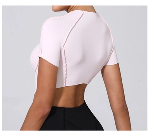 Détail du haut court de yoga rose clair avec un design d'ourlet ondulé irrégulier au dos