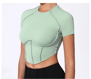 Détail du haut de yoga vert menthe avec coutures apparentes et coupe asymétrique en V