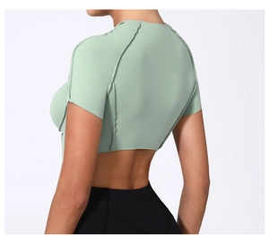 Détail du haut de yoga vert clair avec coutures apparentes et coupe courte au dos