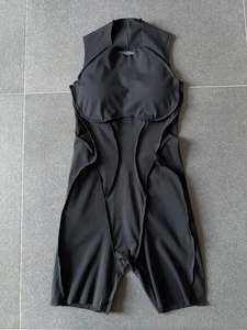 Detail view of black sleeveless one-piece yoga jumpsuit with padded chest and slimming seams