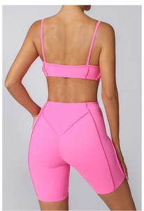 Vue arrière d'un ensemble de yoga rose néon montrant le dos du soutien-gorge et le short