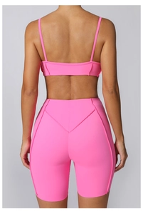 Vue arrière de l'ensemble de yoga rose néon avec brassière et short de fitness gainant
