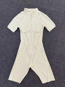 Detailed flat lay of beige yoga bodysuit with short sleeves and front zipper closure