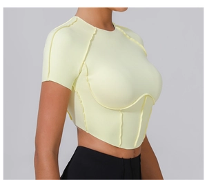 Détail du haut fitness jaune clair avec coutures apparentes et taille en V ajustée