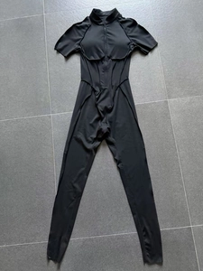 Detailed flat lay of black short sleeve compression jumpsuit with half-zip collar
