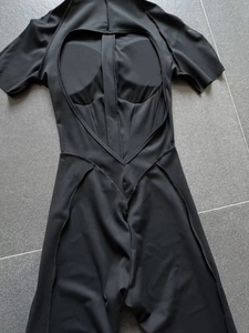 Detailed back view of black short-sleeve yoga bodysuit with U-shape open back and pads