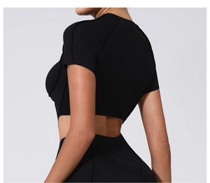 Détail du haut court de yoga noir avec coutures contrastées et coupe moulante sportive