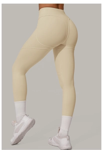 Détail d'un legging de yoga beige taille haute avec couture froncée pour effet galbant