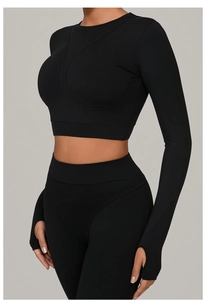 Détail du haut court de yoga noir à manches longues avec passe-pouces et legging assorti