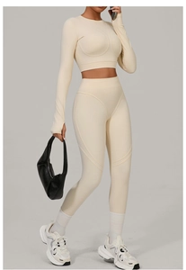Detail view of beige high-waisted yoga set featuring thumbhole cuffs and contoured seams