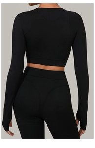 Détail d'un haut de yoga noir à manches longues et d'un legging à taille haute sculptant