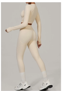 Detail of beige yoga set showing high waist leggings with contour seams and thumb holes