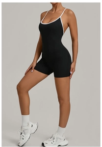 Seitenansicht des schwarzen Yoga-Einteilers mit weißen Kontrastträgern und Slim-Fit-Schnitt