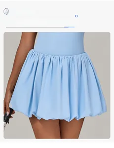 Detail of light blue tennis dress featuring bubble hem design and sculptural pleats