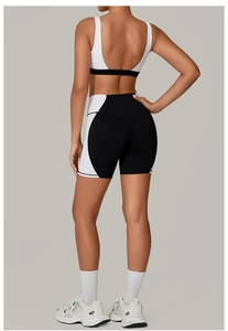Detail view of backless yoga set featuring a white and black colorblock sports bra and shorts