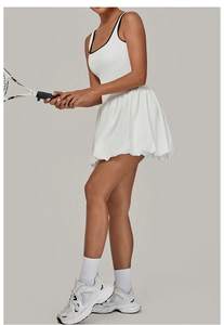 Detail of white sports dress with contrast black piping and pleated tennis skirt