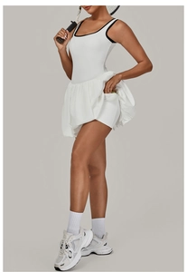 Detail of a white backless tennis dress with black contrast trim and a functional ball pocket