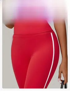 Gros plan sur le pantalon de yoga rouge taille haute avec bandes latérales et coupe ajustée