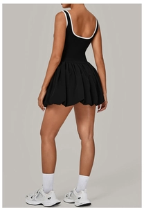 Detail view of the open back design and voluminous pleated hem of the athletic tennis dress
