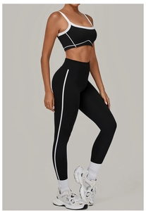 Detail eines schwarzen Yoga-Sets mit weißen Kontrastnähten und High-Waist-Sportleggings