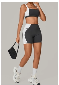 Detail of high-waisted shorts and color-block sports bra set in black and white