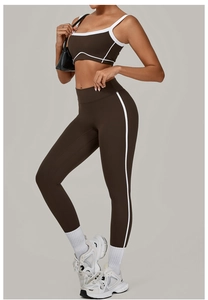 Detailaufnahme des dunkelbraunen Yoga-Sets mit weißen Kontrastpaspeln und elastischem Stoff