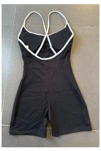 Detailaufnahme des schwarzen Fitness-Bodysuits mit weißen Überkreuzträgern und enger Passform