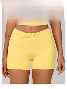 Detail of yellow high-waisted yoga shorts featuring a ruched waistband for fitness