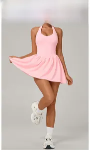 Detail of peach pink halter neck activewear dress with pleated skirt and open back