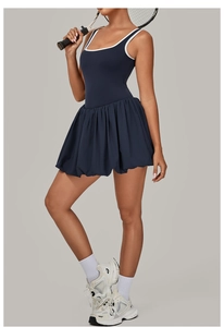 Detail view of the contrast trim neckline and pleated hem on a dark blue tennis dress