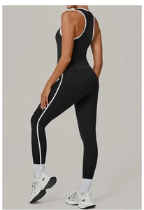 Détail d'un ensemble de yoga avec rayures latérales blanches sur legging et haut noirs