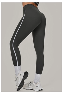 Detailansicht der dunkelgrauen Yoga-Leggings mit weißem Seitenstreifen an einem Model