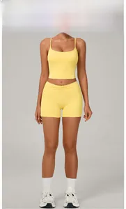 Detail of goose yellow yoga set with side stripes and pleated high-waisted shorts