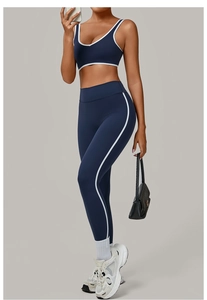 Detail of navy yoga set with white trim showing high waist leggings and a U-neck sports bra