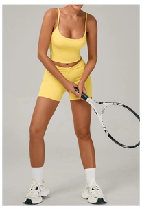 Detail of yellow yoga set with U-neck camisole and high-waisted pleated sports shorts