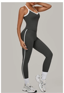 Detailoverzicht van donkergrijs sportsetje met witte contrastbiezen voor yoga en fitness