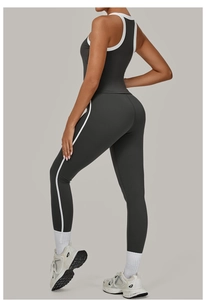 Zijaanzicht van donkergrijze sportset met witte contrastbiezen en een yoga-legging