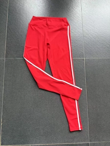 Flach liegendes Detail der roten High-Waist Yogahose mit weißen seitlichen Streifen