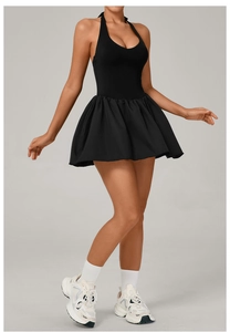 Close-up of black halter neck tennis dress featuring a pleated hem and athletic design