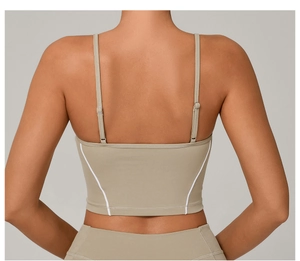 Adjustable thin straps and white trim detail on a beige back-view yoga sports vest