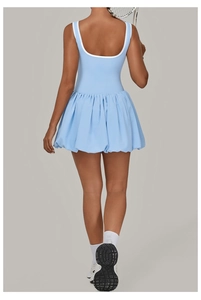Detail of light blue open back tennis dress with white trim and pleated balloon skirt hem