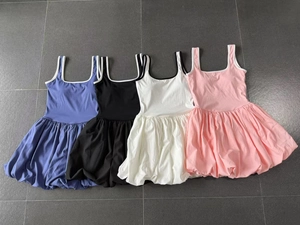 Close-up of four sleeveless tennis dresses with contrast trim in blue, black, white, and pink